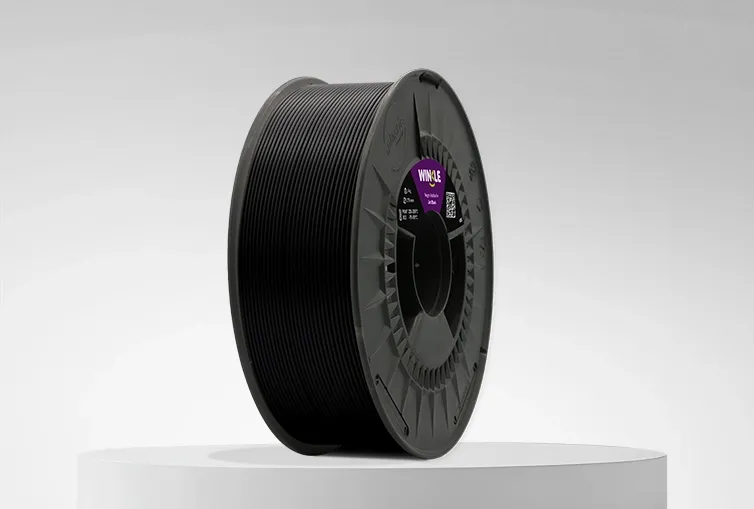 Spule von Filament ABS Winkle 1,75mm Gagat Schwarz 1kg auf einer Plattform und einem grauen Hintergrund