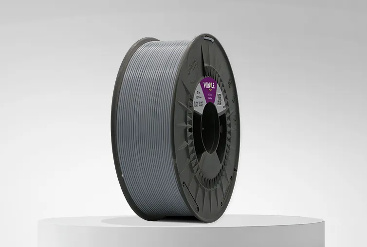 Spule von Filament PETG Winkle 1,75mm Aschgrau 1kg auf einer Plattform und einem grauen Hintergrund