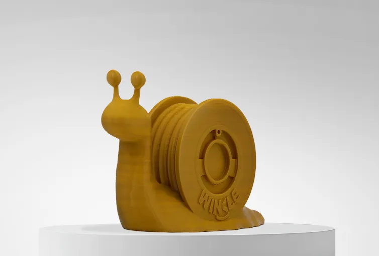 Figura impresa en 3D con Filamento PLA HD Winkle 1,75mm Oro 1kg sobre plataforma y fondo gris