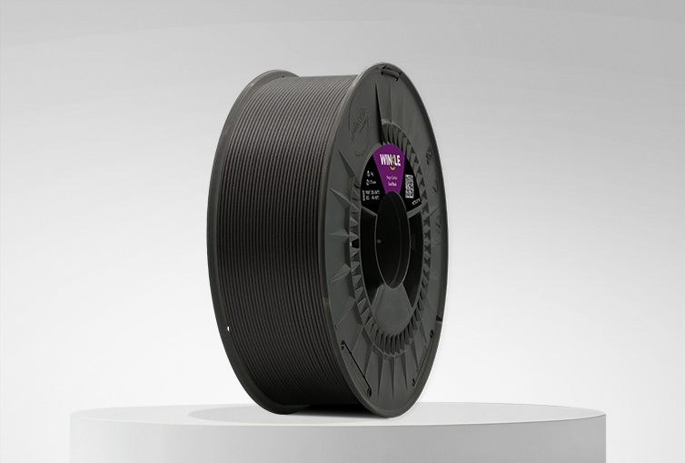 Bobina de Filamento PETG Fibra de Carbono Winkle 1,75mm Negro Carbon 1kg sobre una plataforma y fondo gris